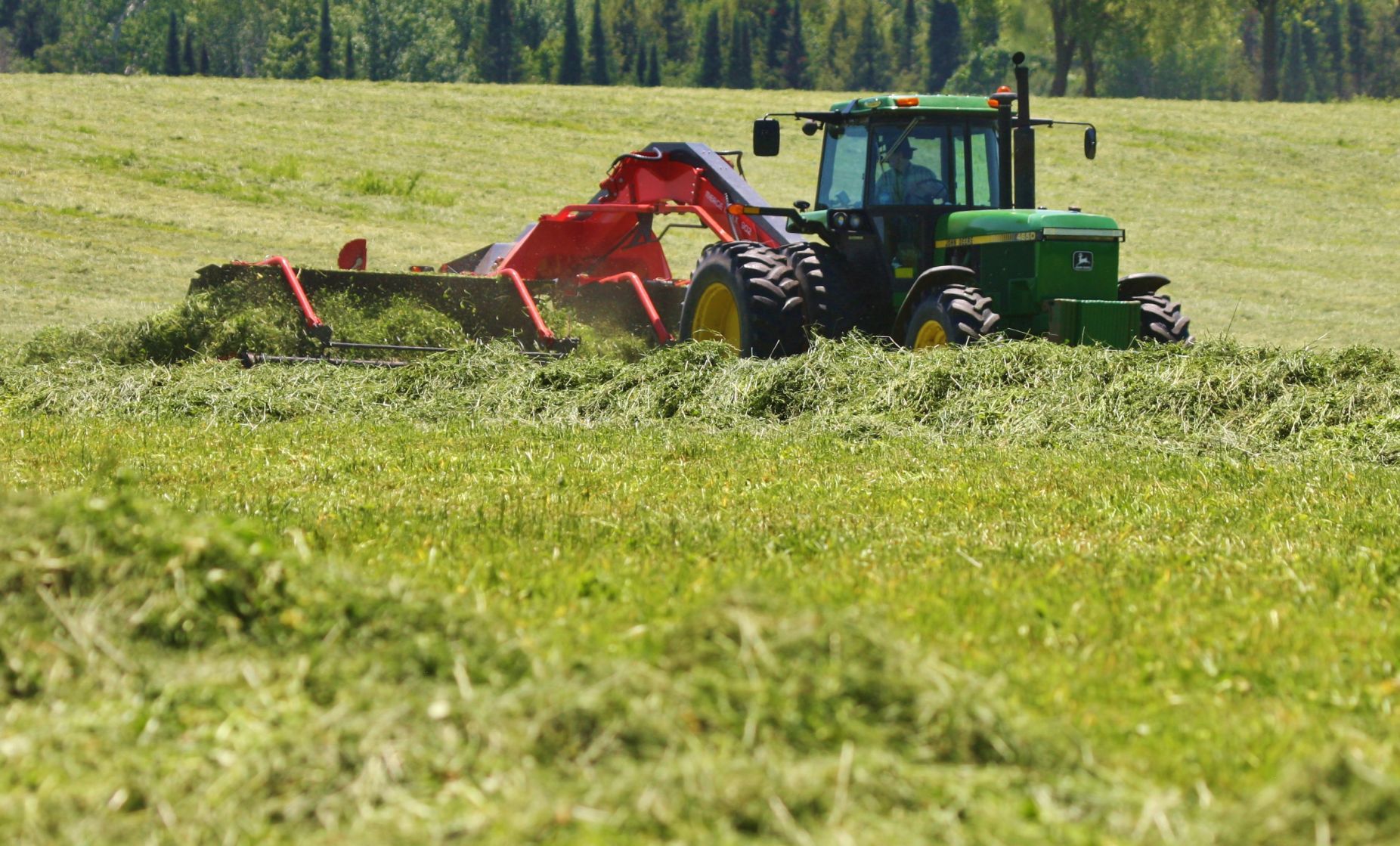 Windrow merger with tractor in field